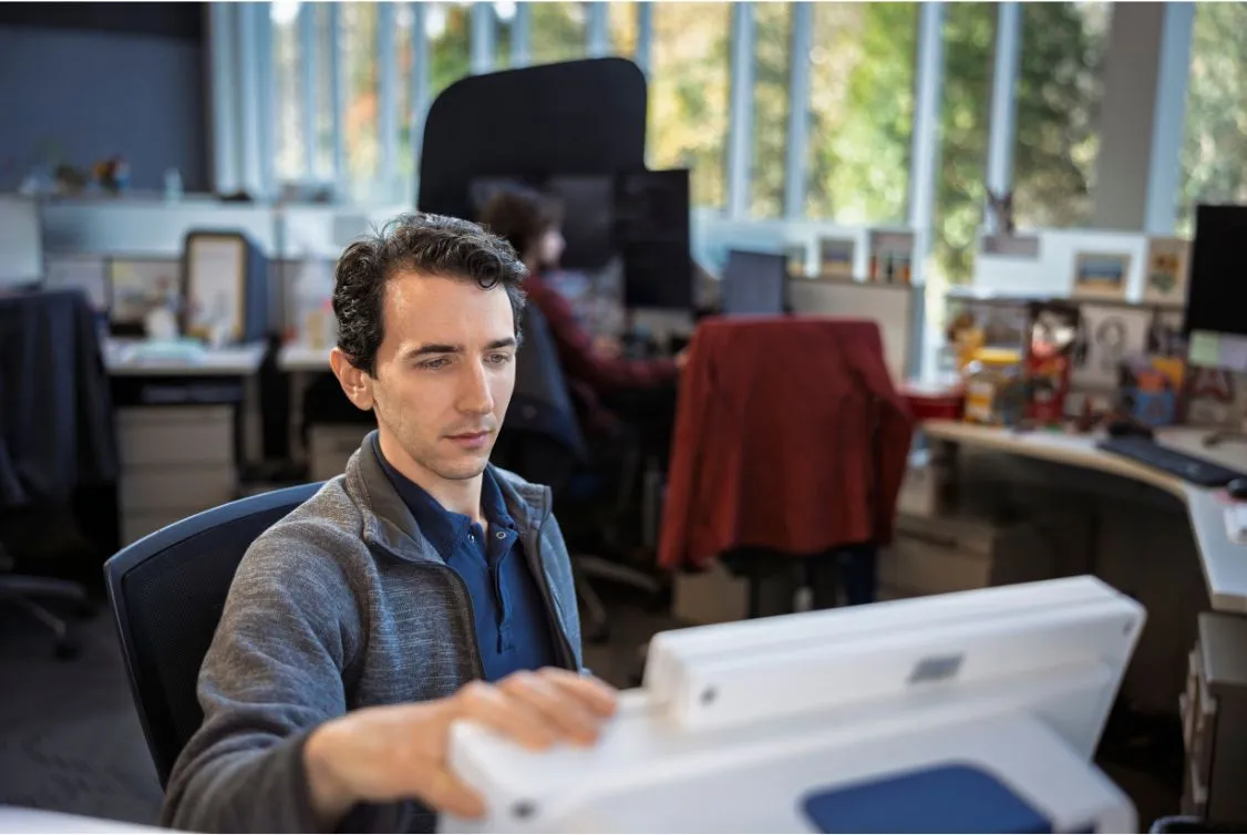 Mann lächelt während einer Konversation und lehnt sich über den Tisch